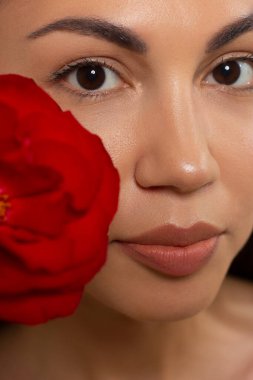 Koyu siyah dumanlı göz makyajı ve son derece uzun kirpik, kırmızı dolgun dudaklı güzel bir kadının portresi. Temiz ciltli, temiz yüzlü, uzun kıvırcık saçlı seksi bir manken.