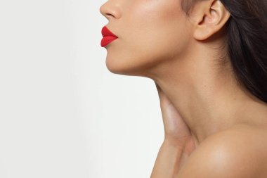 Kırmızı rujla kadın dudaklarının güzelliğini kapat. Kamerada öpüşün. Temiz cilt ve makyaj. Güzel kız ve dudak parlatıcısı