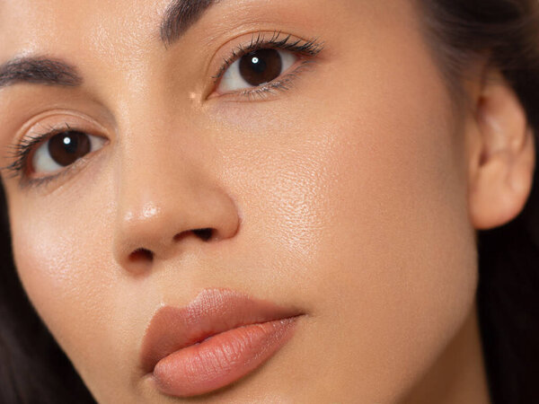 Close-up portrait of a beauty woman with full lips, straight hair and perfectly clean skin. Daytime makeup, styling and soft care. Skin care in the spa salon or cosmetology, smooth eyebrows