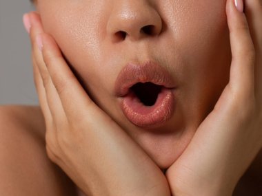 Yakın plan mükemmel dudak makyajı güzel kadın ağzı. Tombul seksi dolgun dudaklar. Makro fotoğraf yüzü detayı. Mükemmel bir cilt, taze dudak makyajı. Tatlı pembe ruj, mor renk. Sevgililer günü tarzı