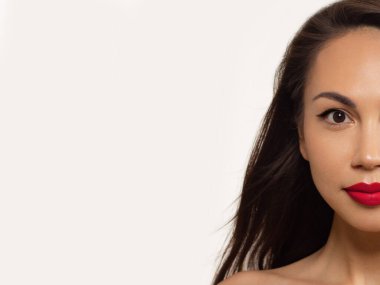 Yarı güzel kadınların yakın çekimi parlak ciltli ve uzun saçlı kırmızı dudaklar. Kaplıca salonunda ya da kozmetolojide yüz bakımı ve modaya uygun dudak parlatıcısı ya da ruj. Akşam makyajı