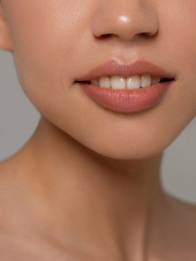 Cinsel dolgun dudaklar. Dudak parlatıcısı ve kadın derisi. Ağız kapalı. Dudaklarda ve kozmetolojide artış. Doğal dudaklar. Açık gözlerle harika bir yaz havası. Pembe dudak parlatıcısı ve beyaz dişler