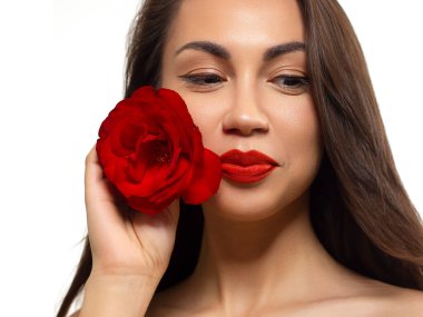 Yeşil gözlü, güzel esmer model kadın yüzü ve mükemmel makyajı kamerada gülümsemesini sağlıyor. Güzel bir portre, kırmızı dudaklar ve göz kalemi, kalın kaş. Açık tenli bir kadın yüzü. Yakın plan.