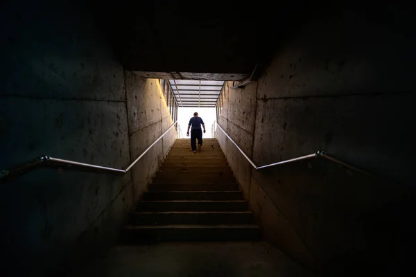 Hombre Caminando Desde Escalera Hacia Luz Ambiente Oscuro — Foto de Stock