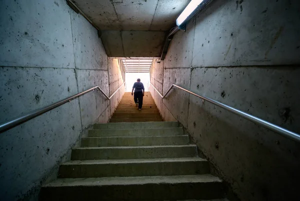 Hombre Caminando Desde Escalera Hacia Luz Ambiente Oscuro — Foto de Stock