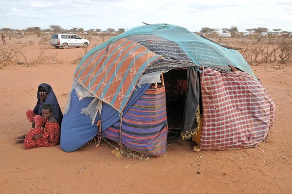 난민 캠프에 앉아 옆 텐트 아이 여자와 스톡 사진