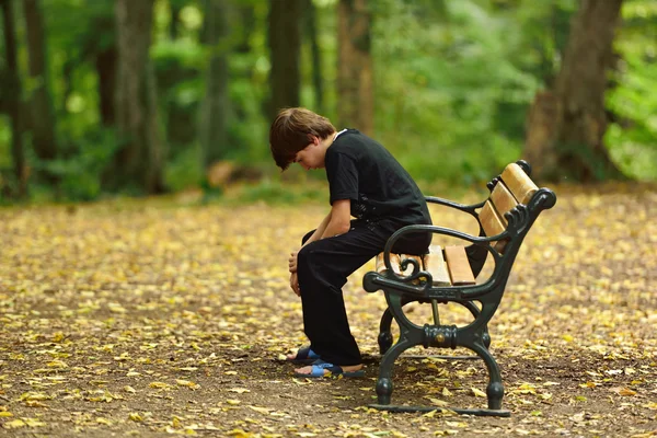 Depressed young man sitting on the bench — Stock Photo, Image