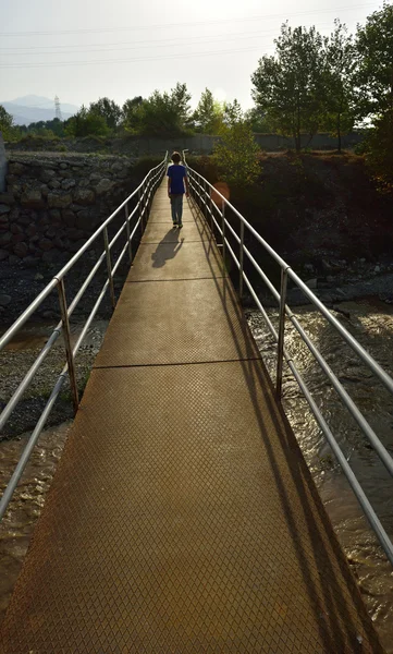 Bambino che cammina sul ponte sospeso — Foto Stock