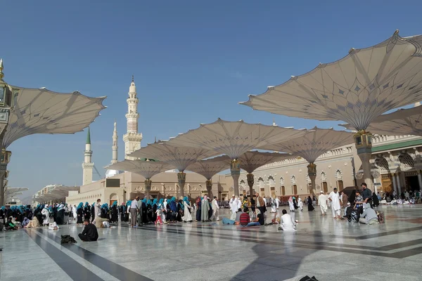 Паломники ходят под гигантскими зонтиками в мечети Набави — стоковое фото