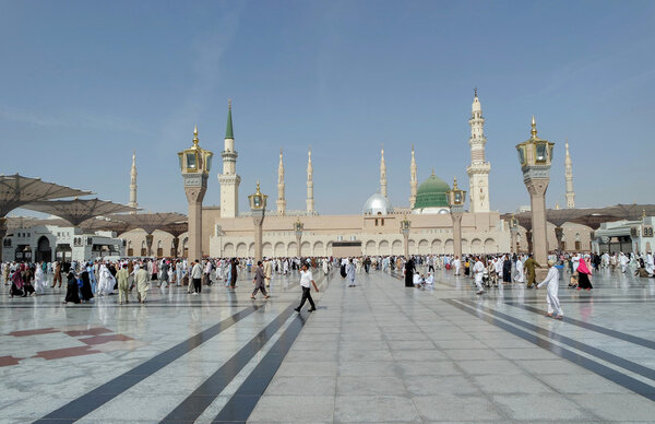 Паломники ходят под гигантскими зонтиками в мечети Набави
