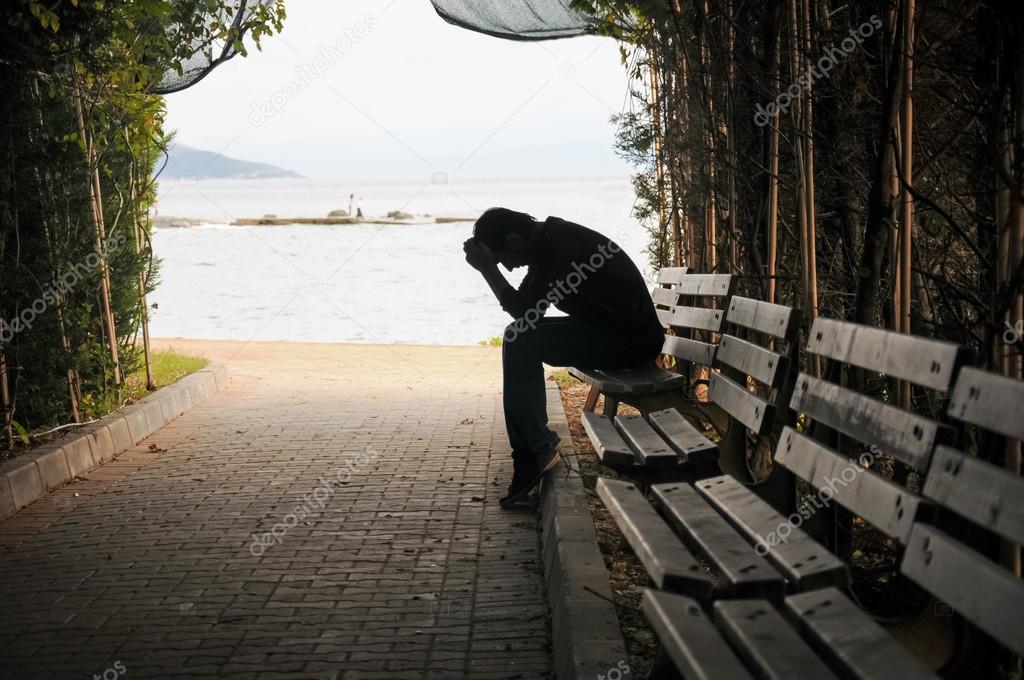 Young man sitting looking upset