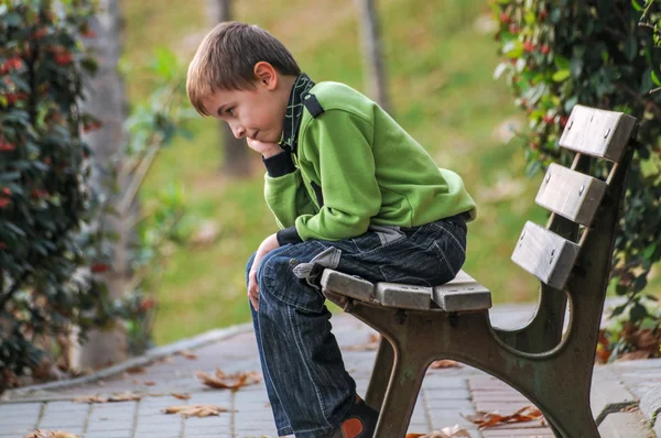 Kind zittend op een bankje — Stockfoto