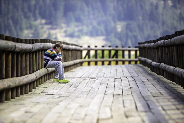 Menino triste sentado sozinho — Fotografia de Stock