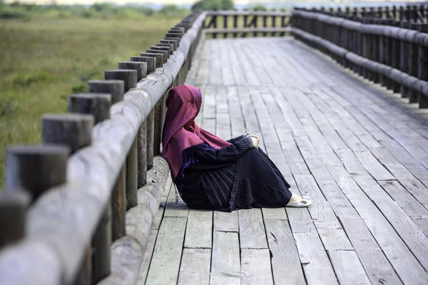 Femme assise sur un chemin en bois dans la nature — Photo