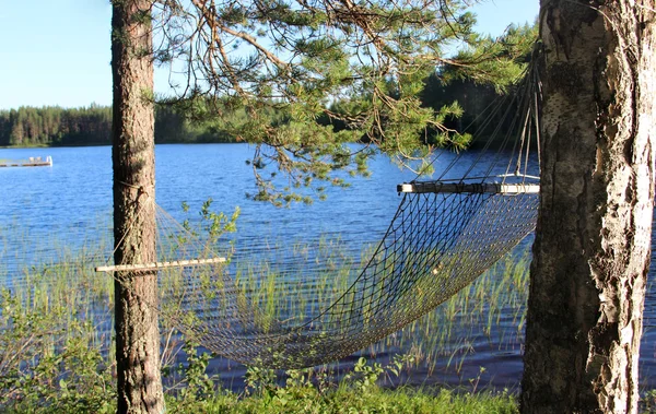 Relaxando perto do lago finlandês na rede — Fotografia de Stock