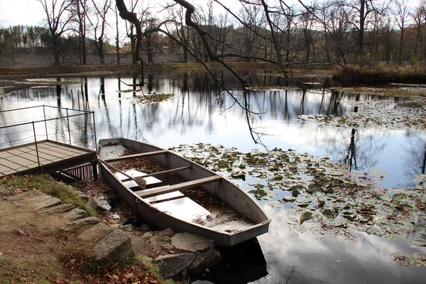 Barco e lagoa na floresta de outono — Fotografia de Stock