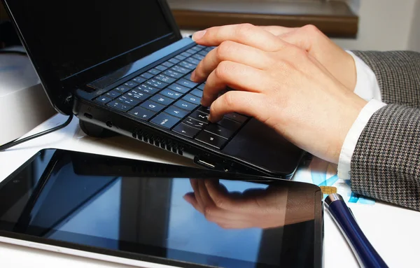 Table de bureau avec ordinateur portable et mains féminines — Photo