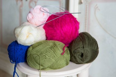 Çok renkli iplikler ve el örgüsü için örgü iğneleri. Örgü örmek ve örgü örmek boş zamanlarında harika bir hobidir..