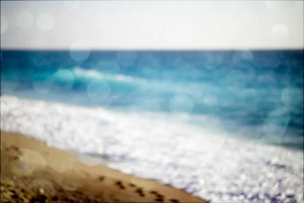 Hintergrund verschwommener Strand und Meereswellen mit Bokeh-Lichtern — Stockfoto