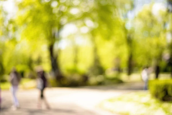 Natural bokeh background of people walking in  park. — Stock Photo, Image