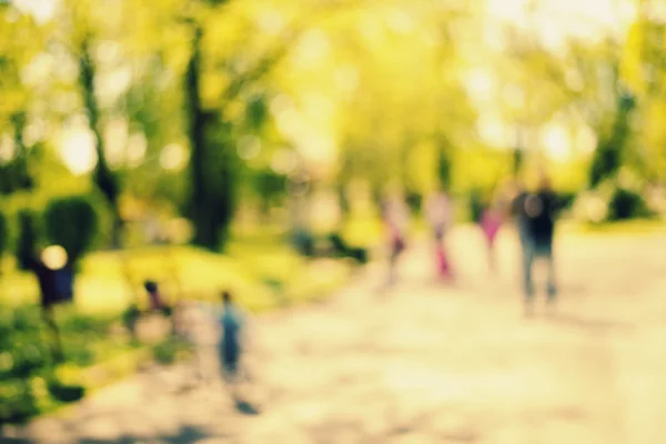 Natural bokeh background of people walking in  park. — Stock Photo, Image