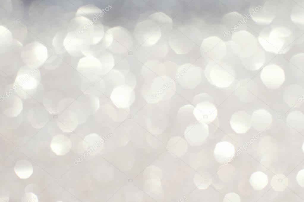 Silver white glittering Christmas lights. Blurred abstract backg