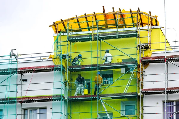 Fyra Arbetare Använder Dekorativa Plåster Fasaden Lägenhetshuset Som Ska Renoveras — Stockfoto