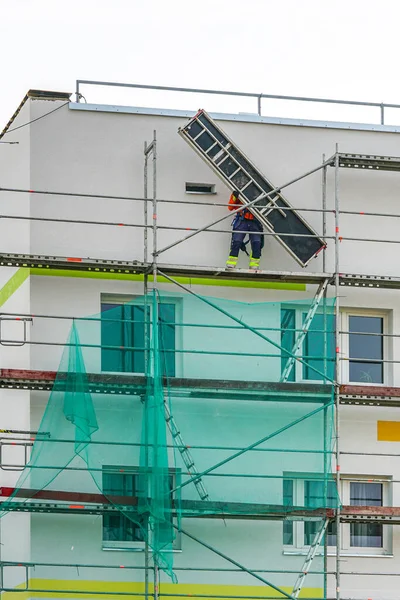 demolition of scaffolding after insulation and renovation of the apartment house facade