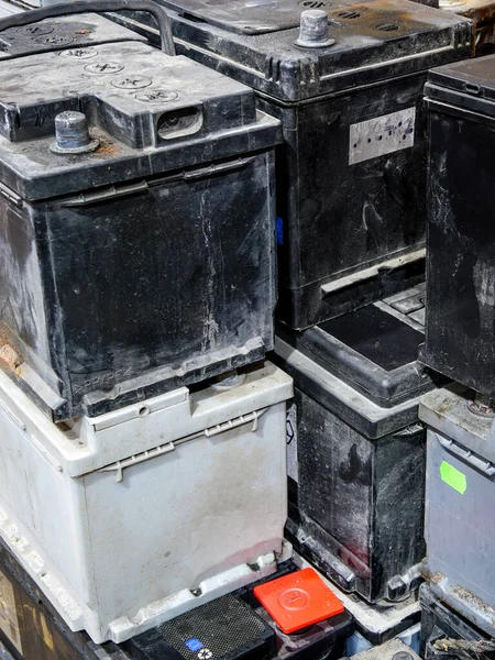 A pallet with used car batteries awaiting recycling at a metal recycling scrap yard