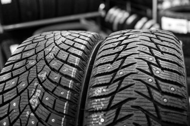 Yakından bakınca, farklı basamaklara sahip iki çivili kış lastiği görünüyor.