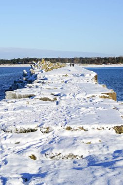 Kış deniz manzarası, liman girişi karla kaplı beton bloklar dalgalı su
