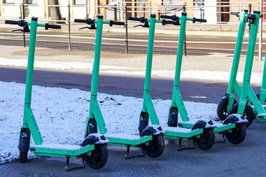 Kar, kışın şehrin bir caddesinde kiralık elektrikli scooter 'larla kaplıydı.