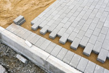 Kaldırım inşaatı manzarası, beton döşemeler ve hazırlanmış çakıl tabanı.
