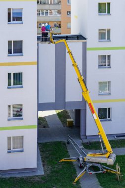 Uzman, modern mobil itişli hidrolik kaldırma platformunun yardımıyla evin ön cephesini inceliyor.