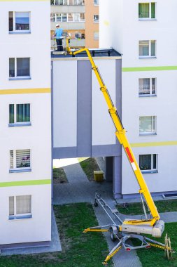 Uzman, modern mobil itişli hidrolik kaldırma platformunun yardımıyla evin ön cephesini inceliyor.