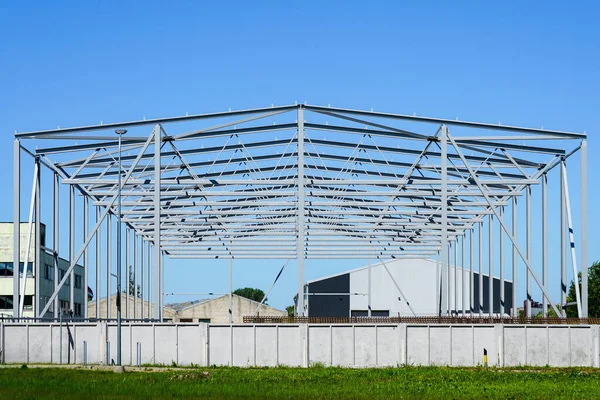 metal frame of a new modern industrial building against a blue sky