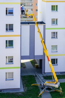 Uzman, modern mobil itişli hidrolik kaldırma platformunun yardımıyla evin ön cephesini inceliyor.