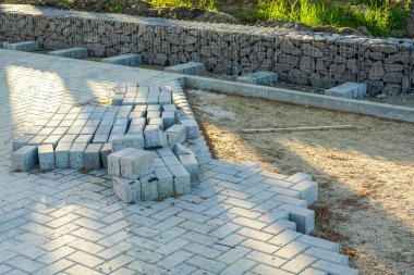 Kaldırım inşaatı manzarası, beton döşemeler ve hazırlanmış çakıl tabanı.