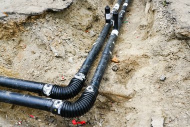 Kazılmış bir siperde, termal izole edilmiş yeni ısıtma borusunun sağ açısı.