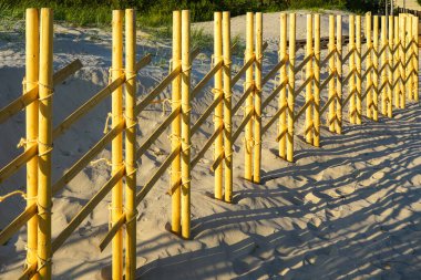 Yeni modern ilginç tasarım kumlu bir sahilde doğal ahşap çit