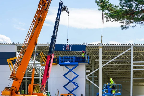 bir sandviç paneli duvarı modern teleskopik vinç ve makas kaldırma yardımıyla monte edilir.