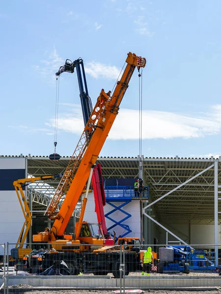 a sandwich panel wall is mounted with the help of a modern telescopic crane and scissor lifts