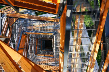 Dekoratif ahşap elementleri ve dairesel merdivenleri olan modern metal gözlem kulesinin bir parçası.