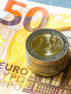 Tasarruf, Avrupa finansmanı, ekonomik büyüme, zenginlik ve mali yatırımı temsil eden 50 avroluk banknota yığılmış iki avro