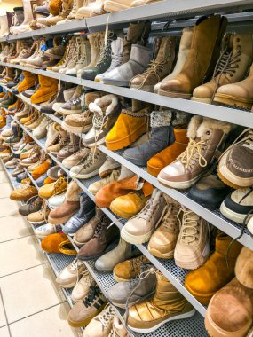 Bir perakende ayakkabı bölümünde çeşitli stiller, malzemeler ve renklerin sergilendiği mağaza raflarında geniş bir seçim yapılmıştır.