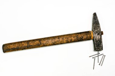 Eskimiş ahşap saplı klasik marangoz çekici ve beyaz arka planda dağınık çelik çiviler. Tamir ve işçiliği sembolize eden klasik el aracı