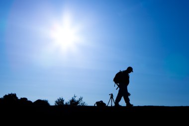 Sırt çantası ile fotoğrafçı silüeti