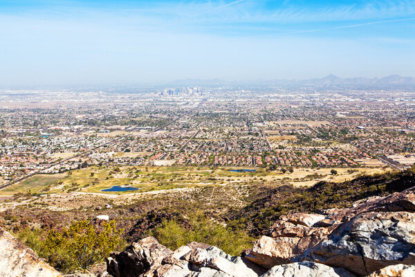 View from Dobbin's Point on South Mountain in Phoenix, Arizona with rocks in foreground and cityscape in background