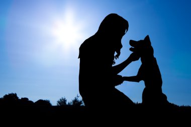 Kızla köpek Sunrise siluetleri