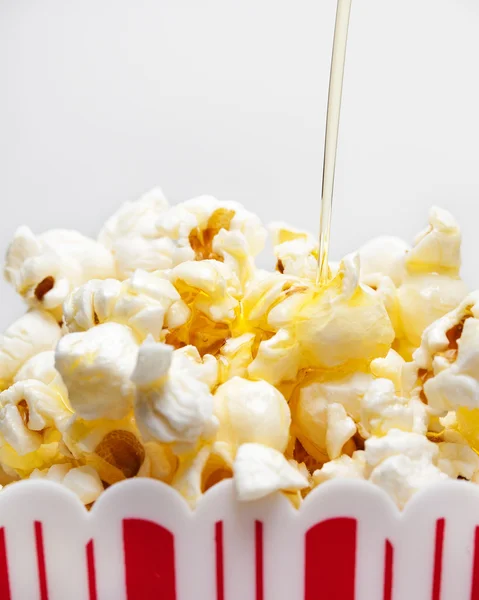 Máslo, mrholení nad Popcorn — Stock fotografie